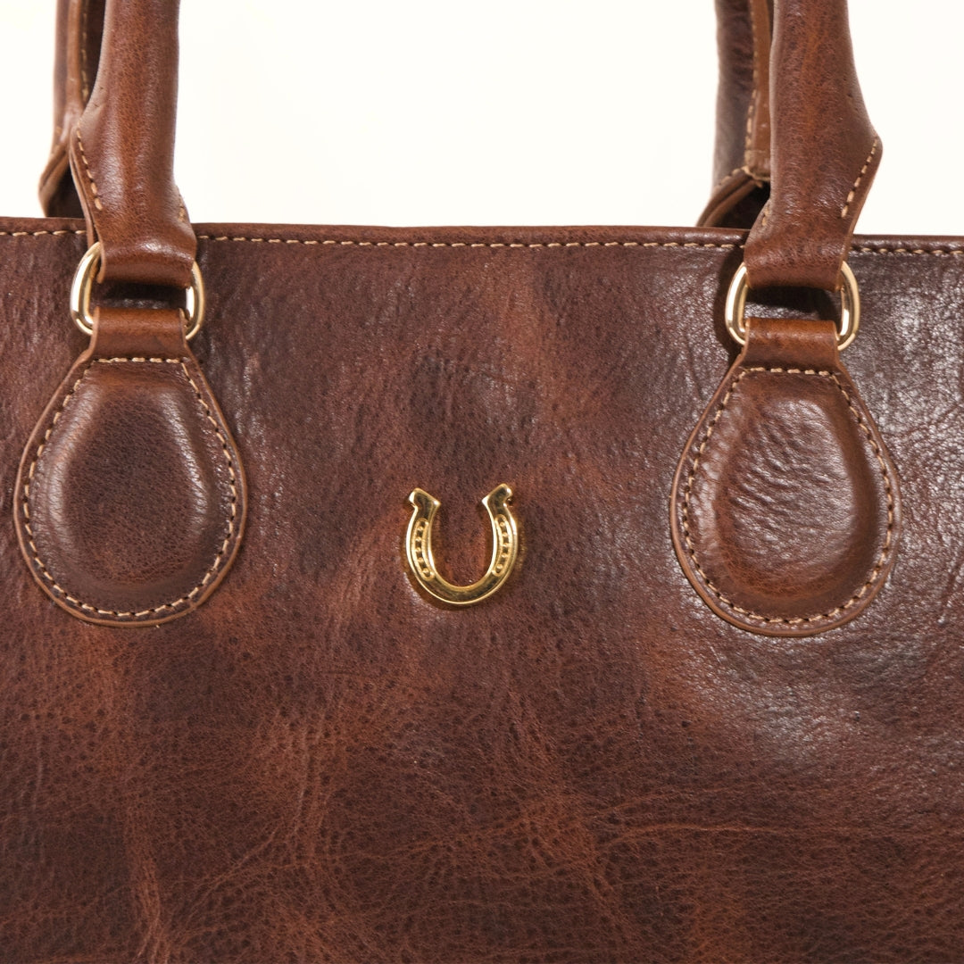 Close-up of gold-plated horseshoe hardware on Martha tote